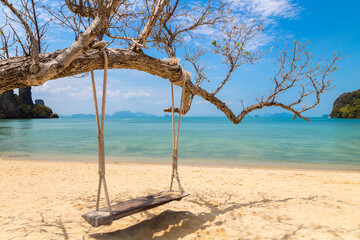 Empty swing at tropical beach