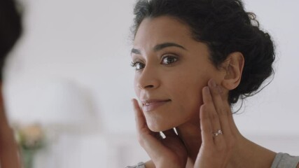 portrait beautiful young woman looking in mirror at perfect healthy skin touching face with hands enjoying smooth natural complexion with anti aging skincare getting ready at home beauty concept - Powered by Adobe