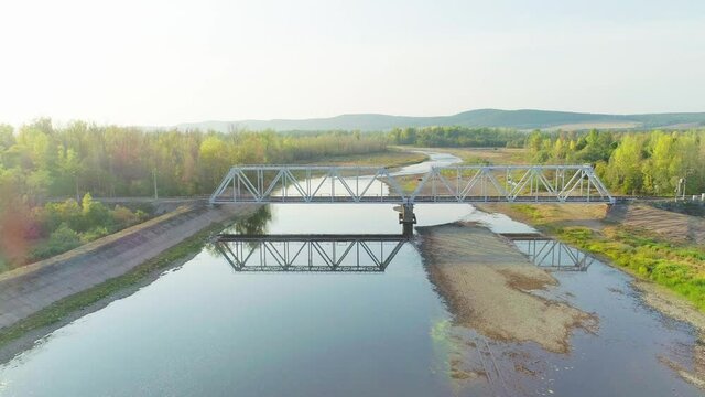 Aerial footage of a railway bridge over a river in the mountains