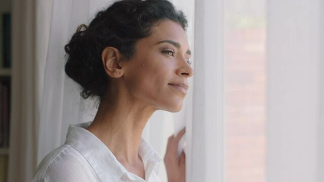 beautiful mixed race woman looking out window at home enjoying fresh new day feeling rested thinking planning ahead 4k footage