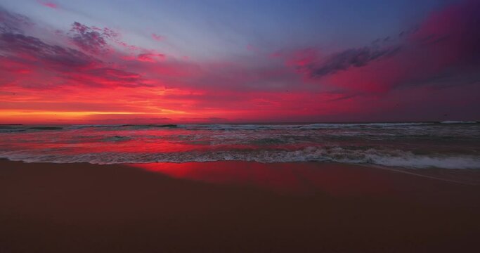 Dramatic sunset or sunrise over the sea waves and beach, slow motion 4k video