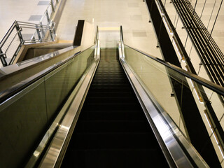 The black electric escalator is moving in the city center station.