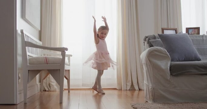 beautiful little girl dancing playfully pretending to be ballerina happy child having fun playing dress up wearing ballet costume with fairy wings at home 4k