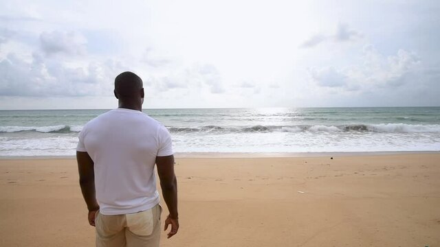 Afro American sports guy looking at sea.