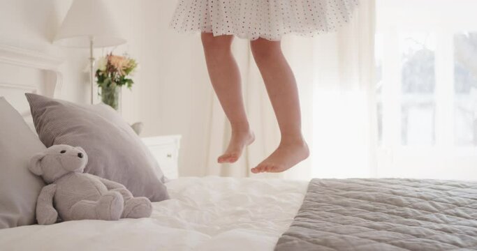 happy little girl jumping on bed having fun child in playful mood enjoying weekend morning at home 4k