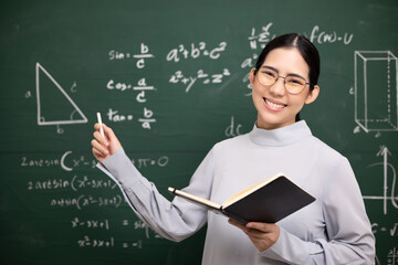 Young asian teacher woman teaching holding book and chalk video conference with student looking...