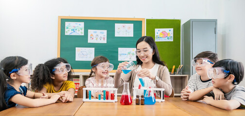 Diversity children doing a chemical experiment in laboratory at school. Portrait of happy kids at elementary school learning science chemistry with asian teacher. Fun study back to school banner