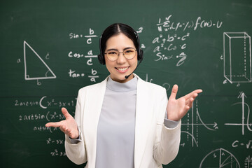Young asian teacher woman wearing headset speaking video conference with student. Female teacher...
