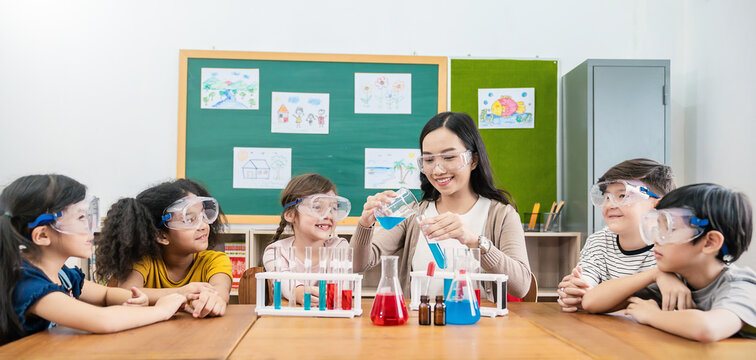 Diversity Children Doing A Chemical Experiment In Laboratory At School. Portrait Of Happy Kids At Elementary School Learning Science Chemistry With Asian Teacher. Fun Study Back To School Banner