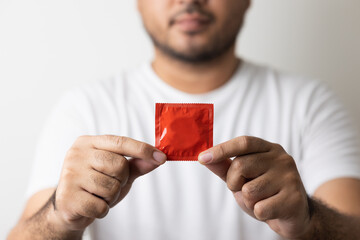 The young man showing the condom into camera. Campaign for safe sex and contraception. Close up...