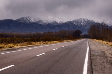 Asphalt road into the snowy Andes mountains in Tupungato, Mendoza, Argentina.