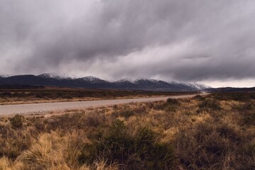 Cold, dry steppe by the snowy Andes mountains, in Tupungato, Mendoza, Argentina, in a dark cloudy day.