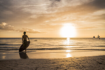 Surfer on the beach at sunset. 