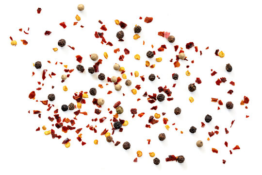 Peppercorns and red hot chili flakes scattered over white, top view, isolated.