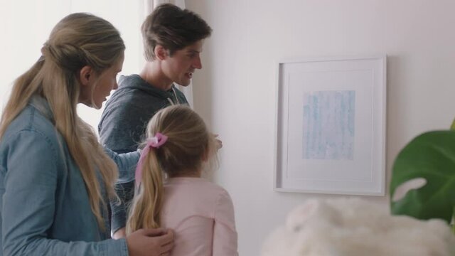 happy family moving into new home owners hanging picture decorating house together with children young couple enjoying real estate property investment with kids 4k footage