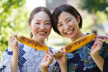 焼きとうもろこしを食べる女性