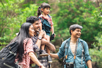 A group of young Asians are planning and looking at maps for camping in the forest.Asian and caucasian are backpackers.Tourism, adventure and summer vacation concept