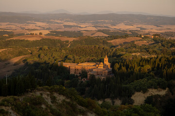 The Abbey of Monte Oliveto Maggiore is a large Benedictine monastery in the Italian region of Tuscany with Karst landscape near Small village Chiusure photographed with a drone.