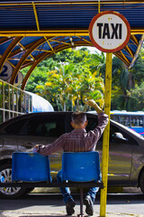 Taxista esperando pacientemente no ponto