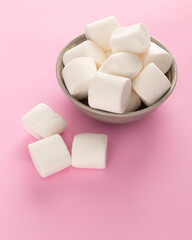 Marshmallow in bowl on pastel pink background.