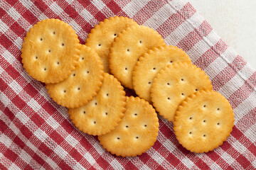 Cracker cookies with tablecloth on white wooden table background.