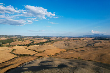 Fototapeta na wymiar Beautiful idyllic late summer landscape of Toscana with photographed with drone. Sunny day in Italy. Vacation, recreation mood. Agricultural fields of Tuscany 