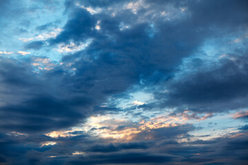 Naklejka na ściany i meble Blue clouds with twilight . Sun glowing in the dark clouds
