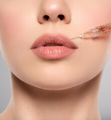 Woman getting cosmetic injection of botox in lips, closeup. Woman in beauty salon, plastic surgery clinic. Cosmetology procedures concept. Beauty treatment therapy.