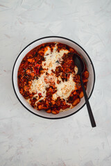 vegan white beans shakshuka with peppers and olives topped with dairy-free cream, healthy plant-based food
