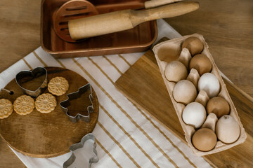 Christmas flat lay. Ginger cookies and molds on a wooden board and chicken eggs. Dessert preparation