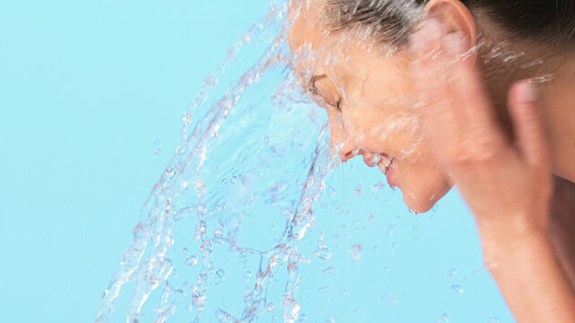 Woman washing her clean face with water. Closeup face of an Young  girl washing face with water.