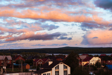 Beautiful nature landscape. Rainbow in the sky and cottages in the village near the lake.