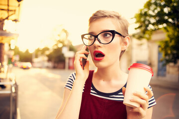 woman with short hair cup of coffee with glasses talking on the phone