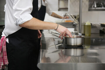 Busy restaurant kitchen. Chef and cooks preparing dishes.