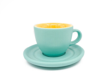 Close-up of empty cyan cup with cyan plate. Yellow colour inside of the coup. White background