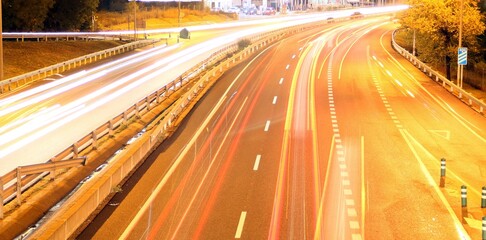 Fototapeta na wymiar Tráfico nocturno en el la carretera M-607 en Madrid, España. Luces de los coches en movimiento tras una larga exposición desde el puente de Tres Olivos.