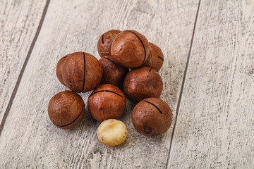 Brown macadamia nut heap over background