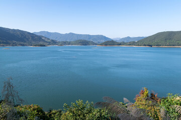 Opposite the lake is the mountain, the sky is blue and the lake water is blue