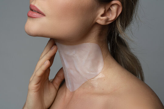 Woman With A Moisturizing And Anti Aging Sheet Mask Applied On Her Neck