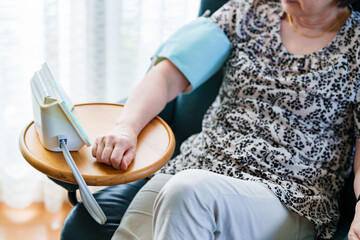 Japanese senior woman measures blood pressure