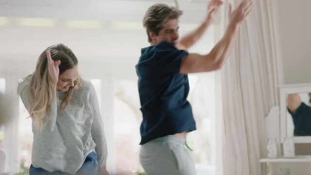 happy young couple dancing at home celebrating having fun weekend morning together enjoying funny dance in bedroom successful relationship celebration 4k footage
