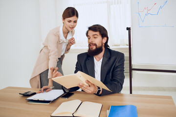 man and woman sitting at a desk office work technology communication
