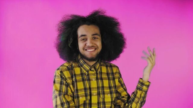 Blah, Blah, Blah. A bored African-American, gesturing with a Blah-Blah gesture, tired of conversations and uninteresting information, posing on a pink background