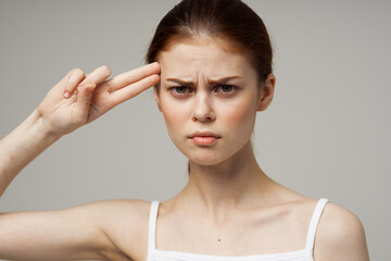 woman in white t-shirt holding head migraine disorder isolated background