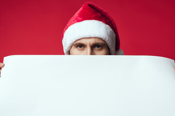 Cheerful man in a santa hat holding a banner holiday isolated background