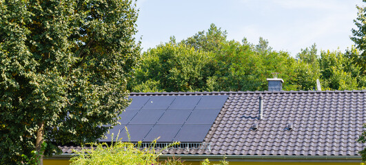 Photovoltaic system on the gray tile roof, solar energy concept, renewable energies