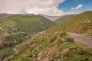 Idyllic Armenian landscape with mountains and a stream. On the slope of Mount Aragats.
