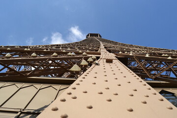 Top of the eiffel tower and many rivets on steel material and blue sky