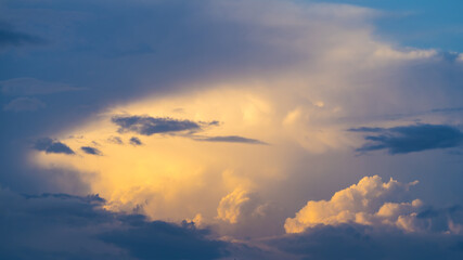 Bizarre sky sight at sunset, sunlit clouds among darkness