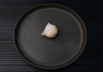 steamed har gao prawn wrapped in crystal skin dumpling on dark grey wood background dim sum menu